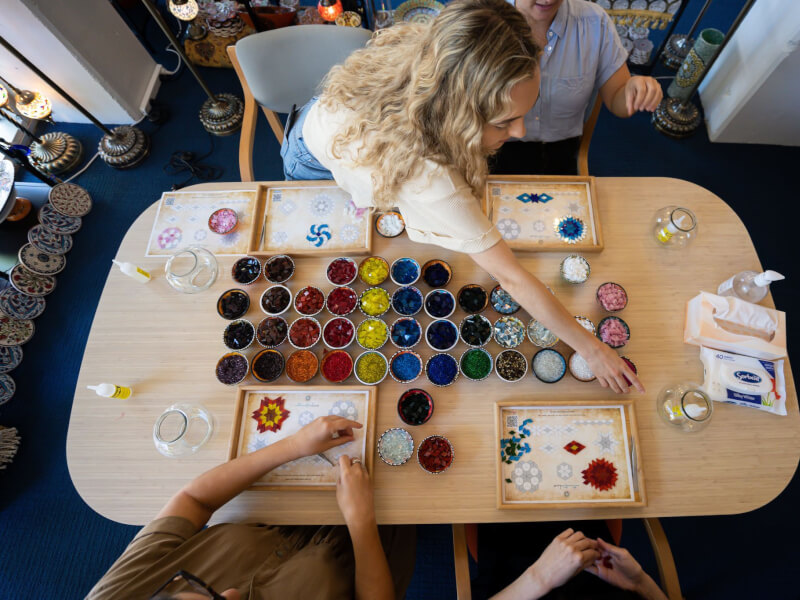 A top view of a group making mosaic art at a craft class in Manchester.